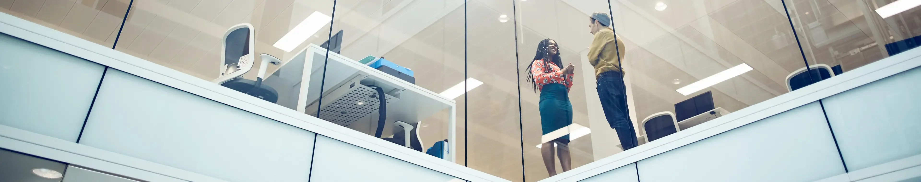 Colleagues talking in a modern office space.